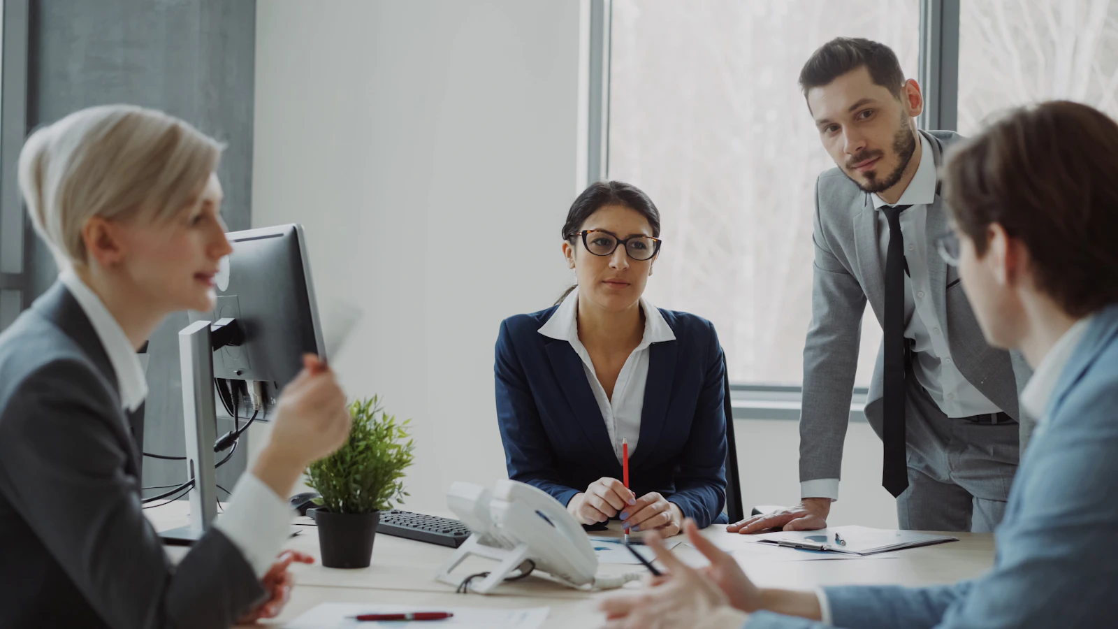 An executive coach in a boardroom meeting with senior leaders
